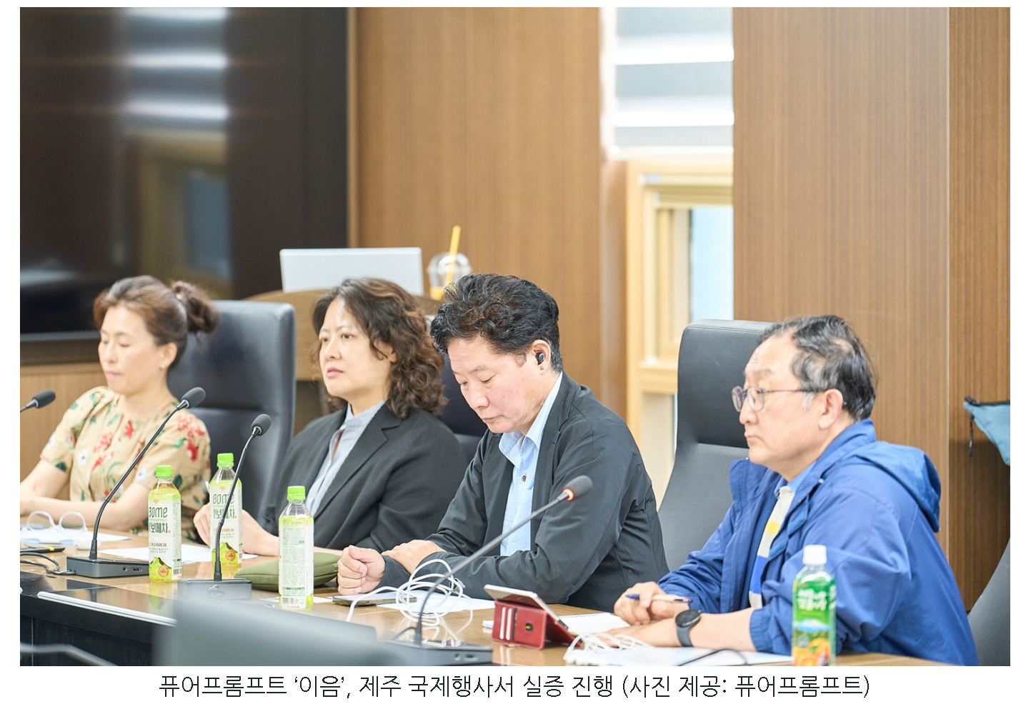 제주 국제행사에서 이어폰과 스마트폰을 이용해 이음 통역 실증에 참여하는 참석자들